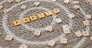 Scrabble pieces on rug spell "family"