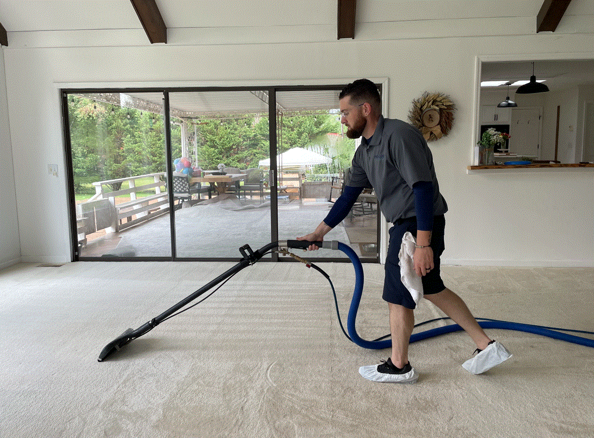 Professional carpet cleaning can help prevent damage.  This technician is shown doing hot water extraction on a white family room carpet.