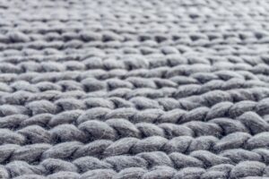 Close up of blue rug fibers in a woven rug.