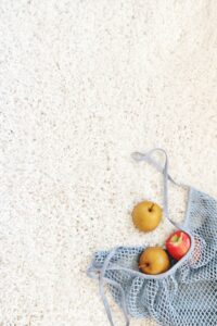 Fruit spilled across white carpet.