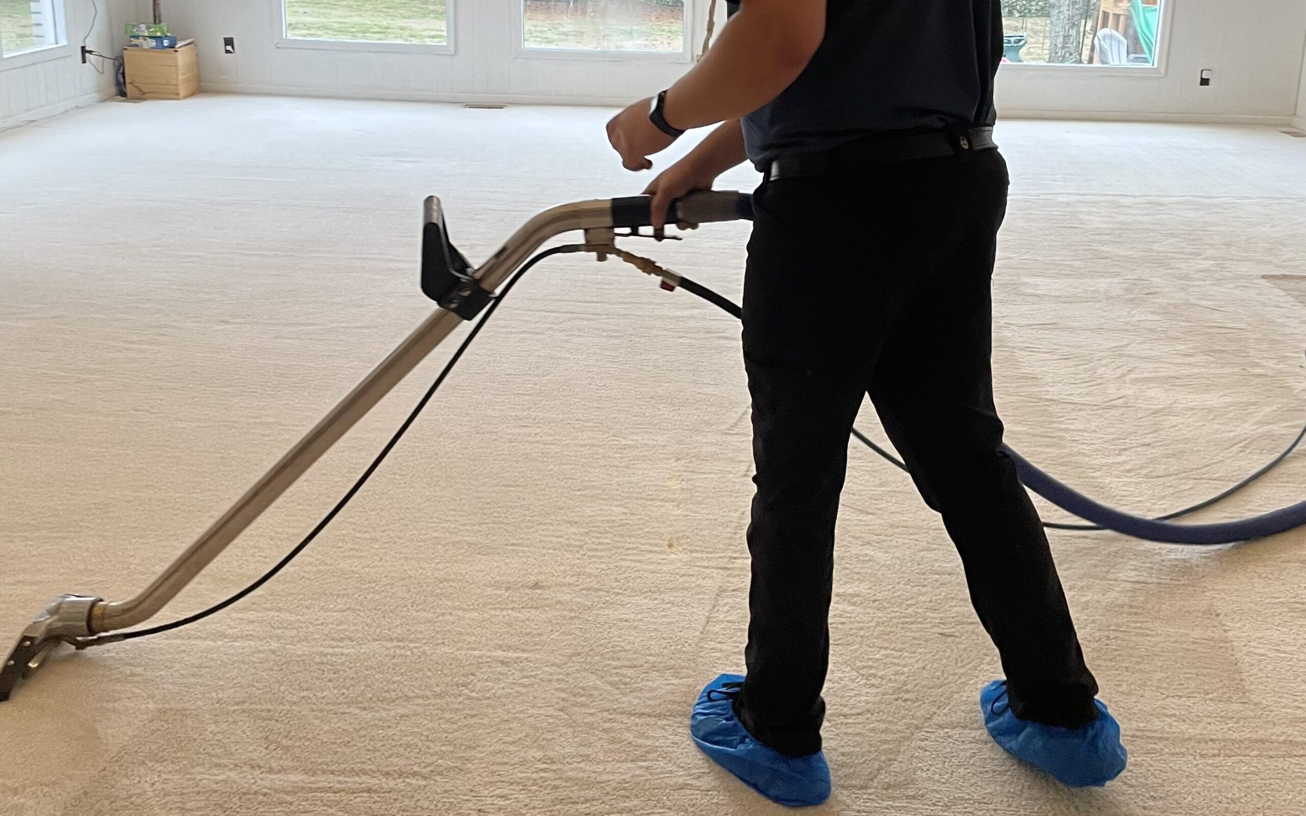 Technician extracts ivory carpet in client's home.