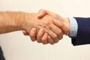 Closeup between handshake between 2 men.