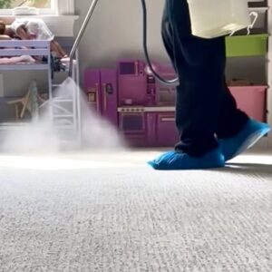 Closeup of Tech's feet while spraying protection on white carpet.