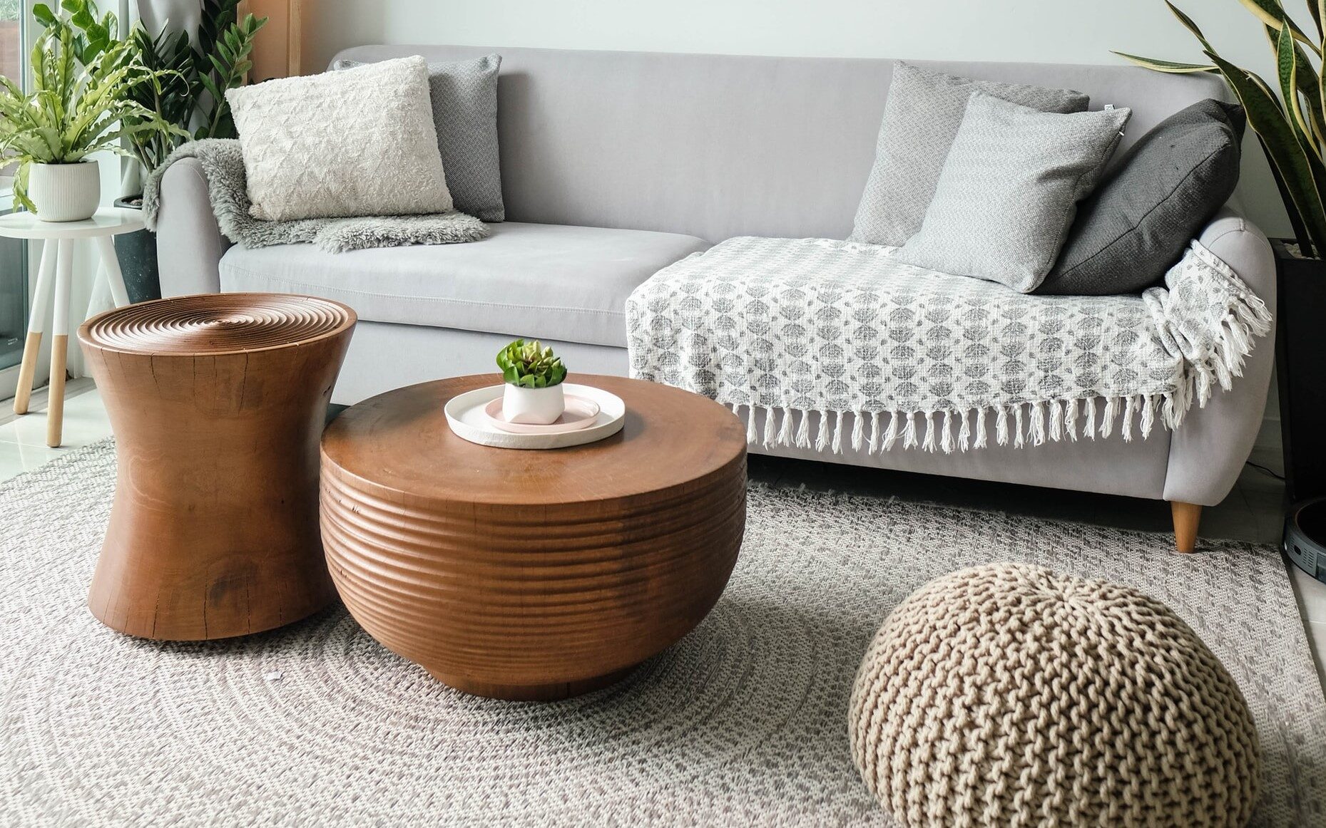 White living room featuring pouf and area rug.