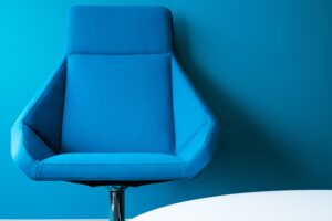 Blue contemporary office chair against blue background.