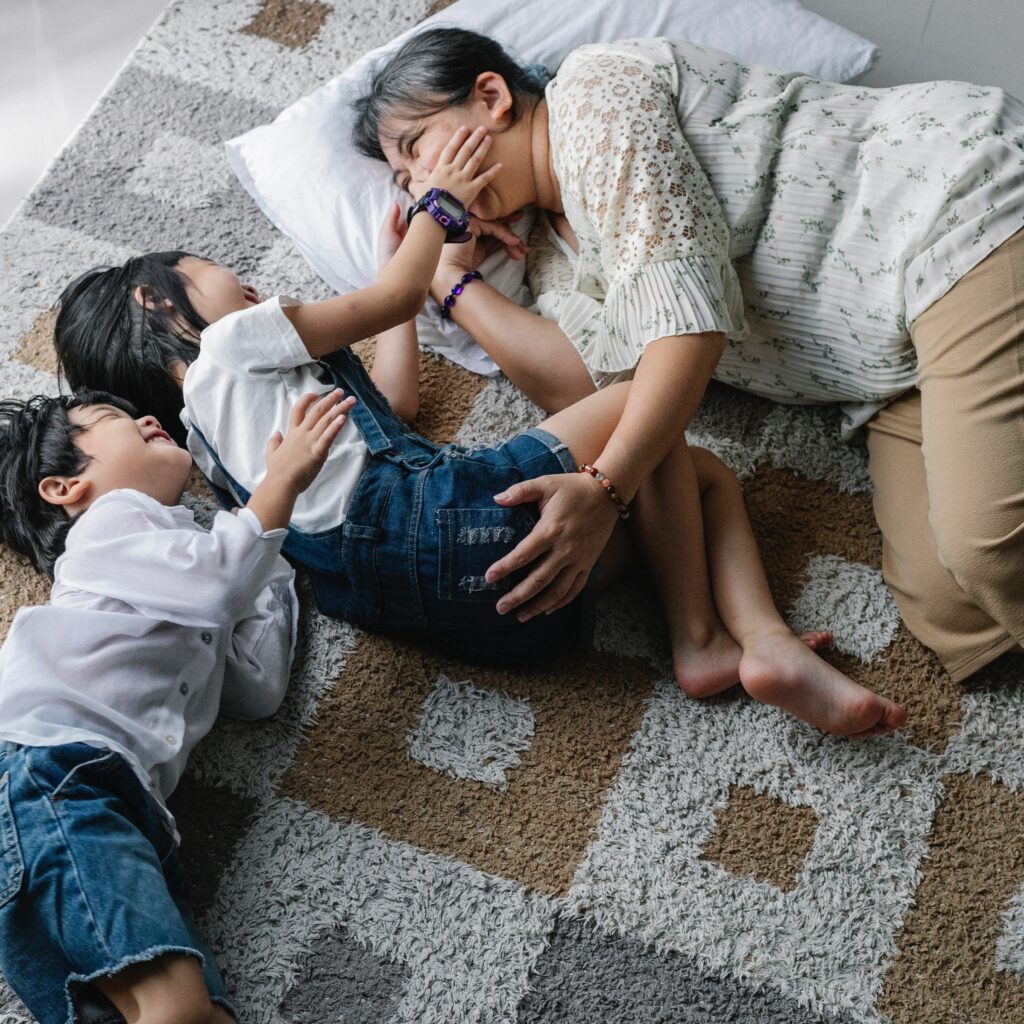 Family tickle session on a high-contrast rug.